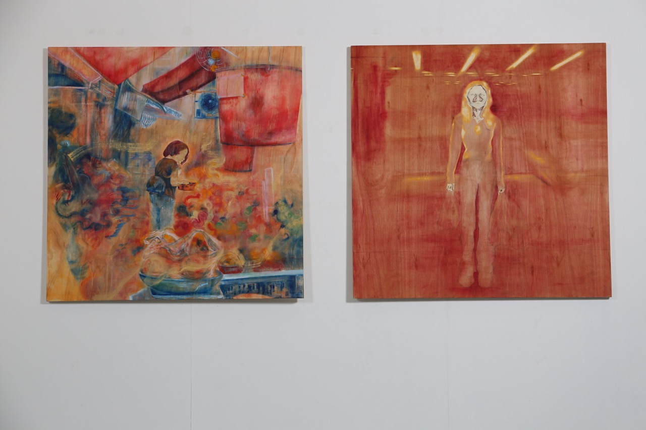 Two abstract paintings hang on a white wall, one showing a crowded multicoloured scene and the other a red-toned standing figure.