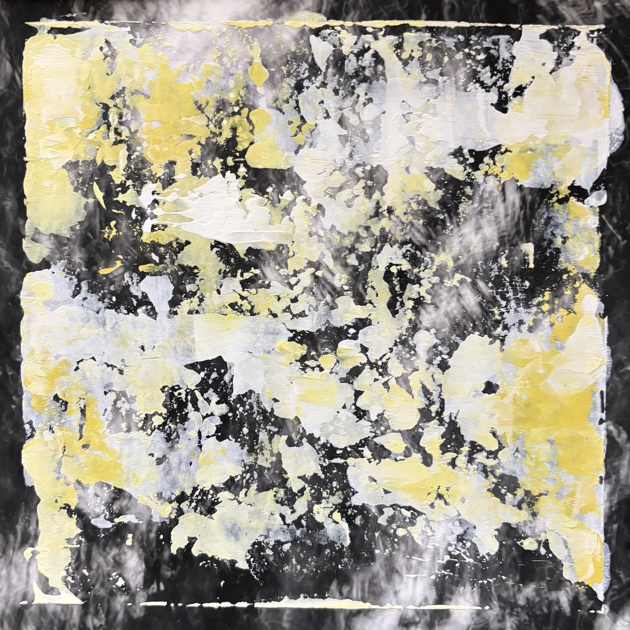 An abstract painted canvas with layered yellow, white and black brushstrokes and splatters, framed by a darker border.