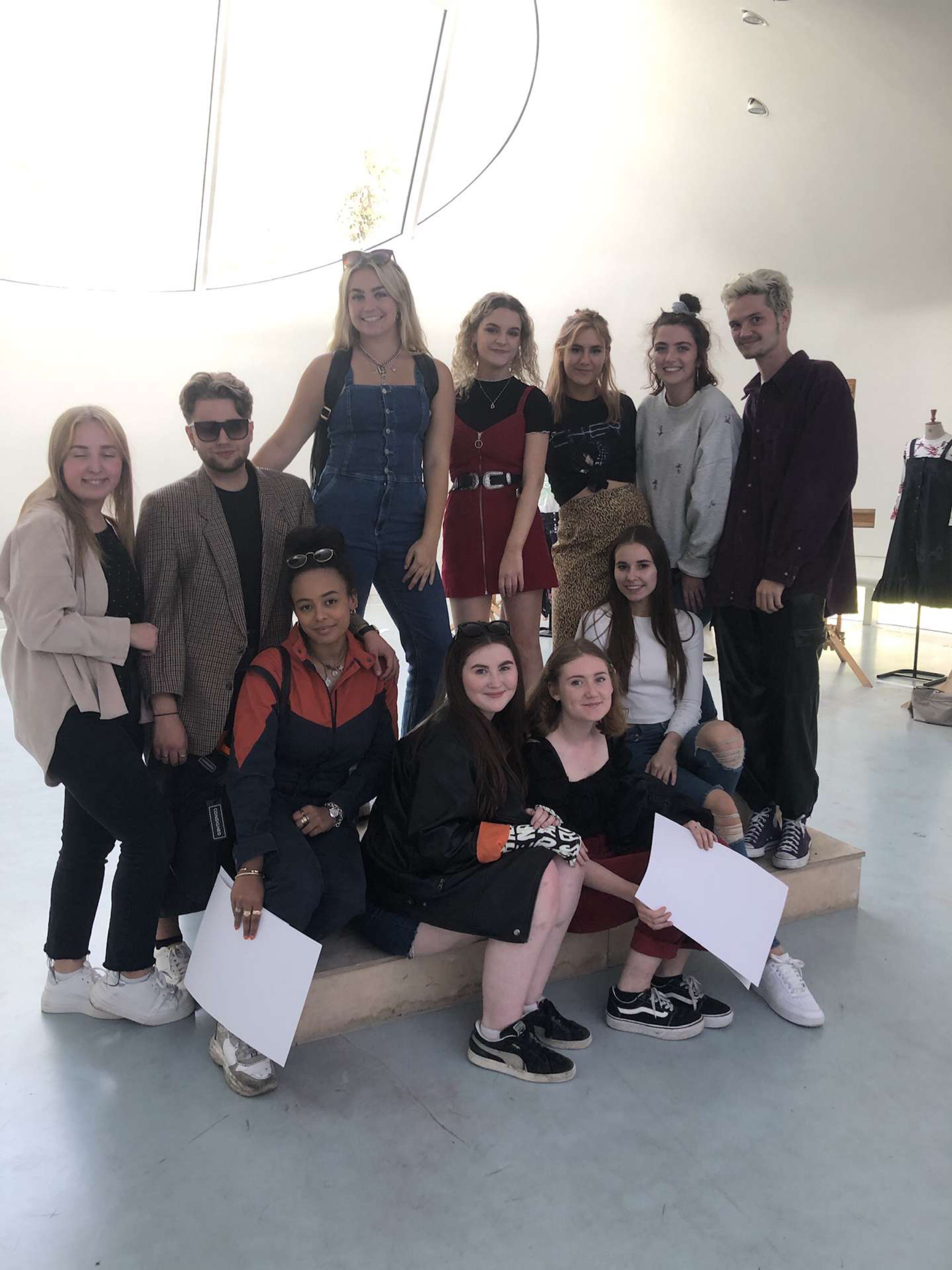 11 people gather in a group and pose for a photo.