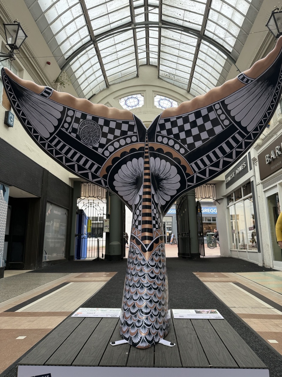 Pia Elliot's tail at Westbourne Arcade, floral art deco-style patterns in black, purple and gold.