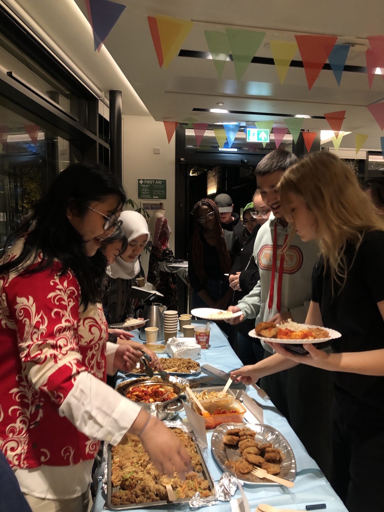 Attendees of the Indonesian Cultural Harmony event at Madeira Road Halls of Residence serving and trying Indonesian food.