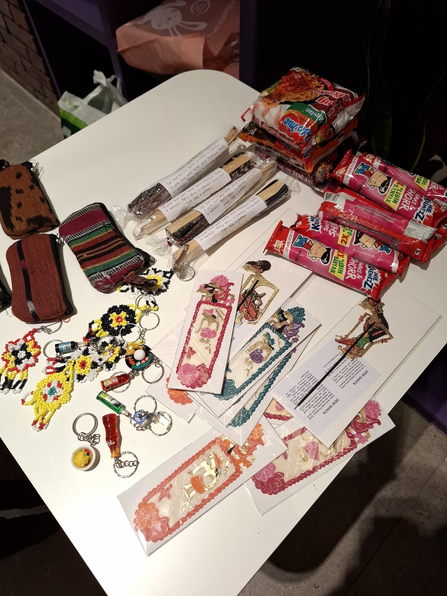 Indonesian-style crafts, wallets and sweets on display on a white table.