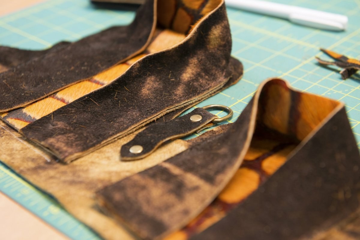 Close up of several pieces of leather on a cutting matt