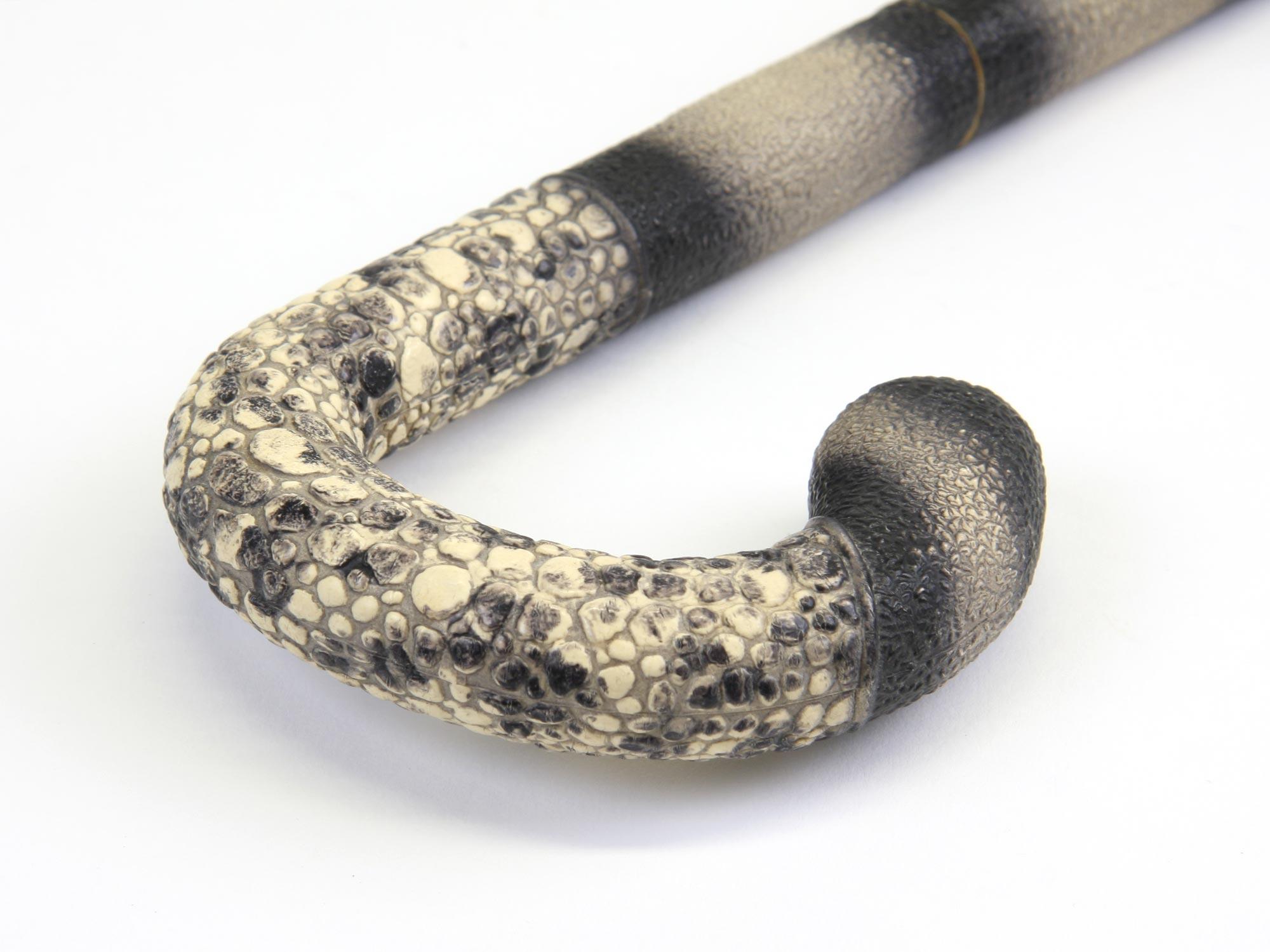 Plastic walking stick with lizard skin texture on the handle