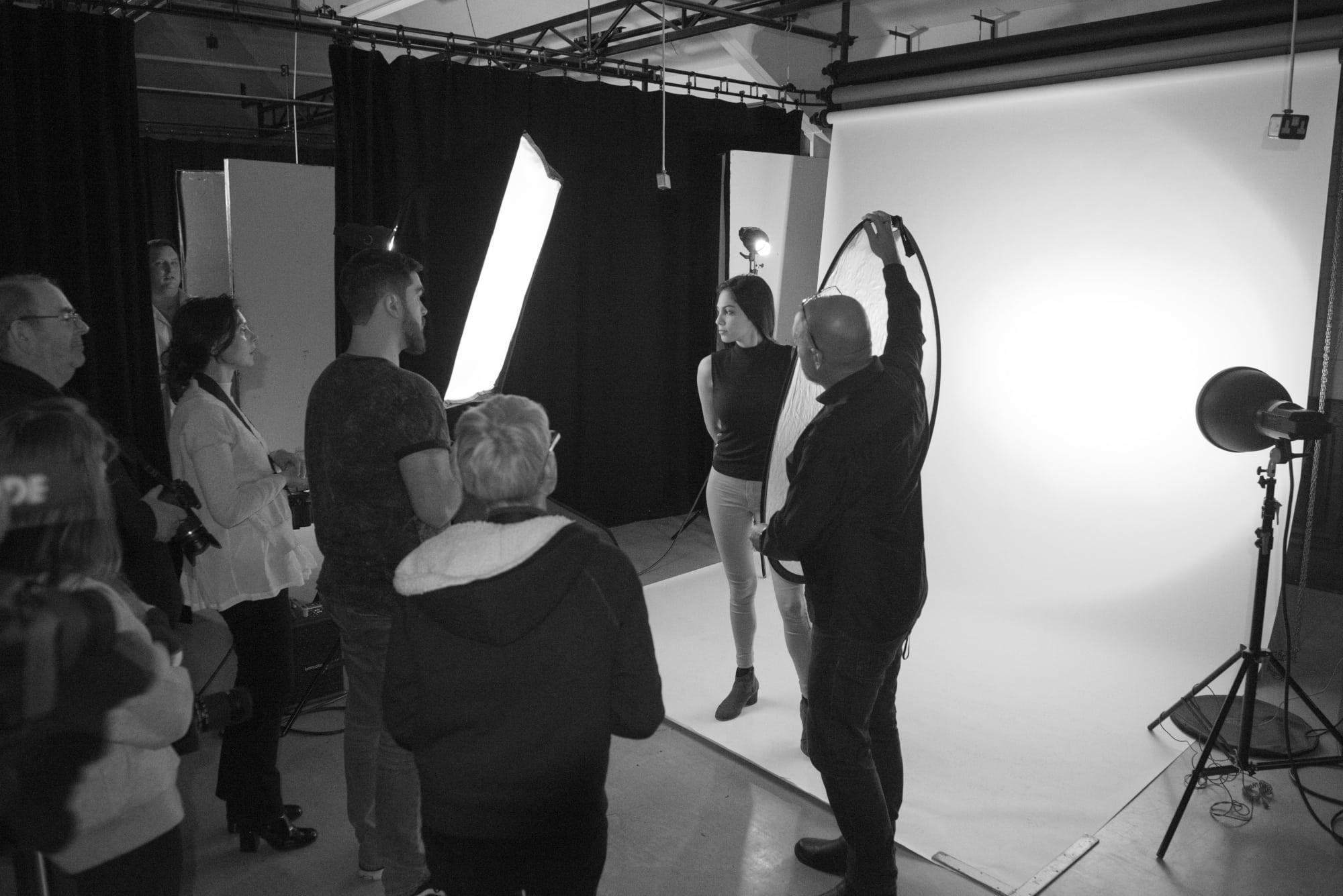 Student's working in a photography studio taking photographs of a model