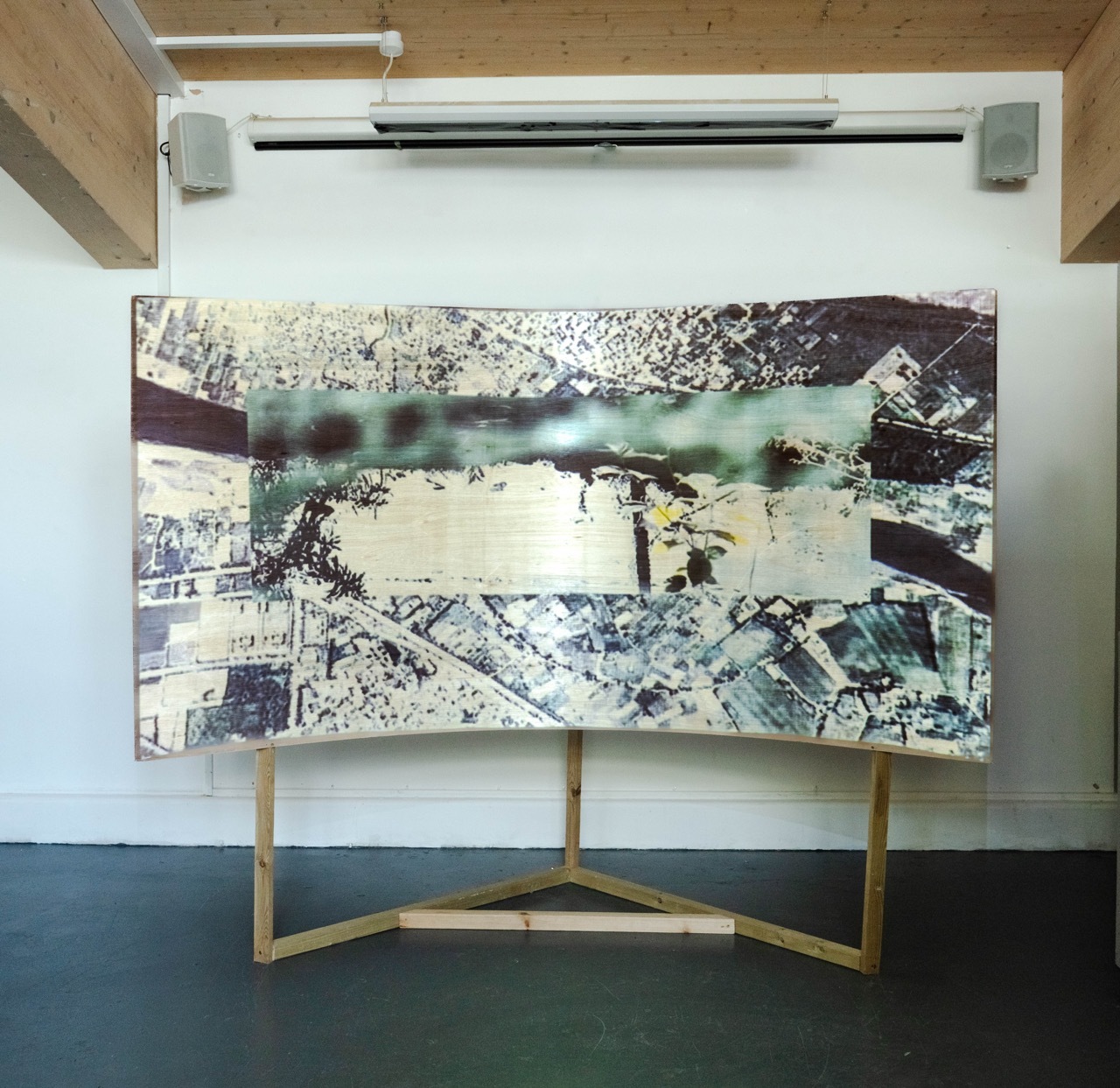 Still frame of a video with a map overlapped with an image of a net on a wooden curved stand.