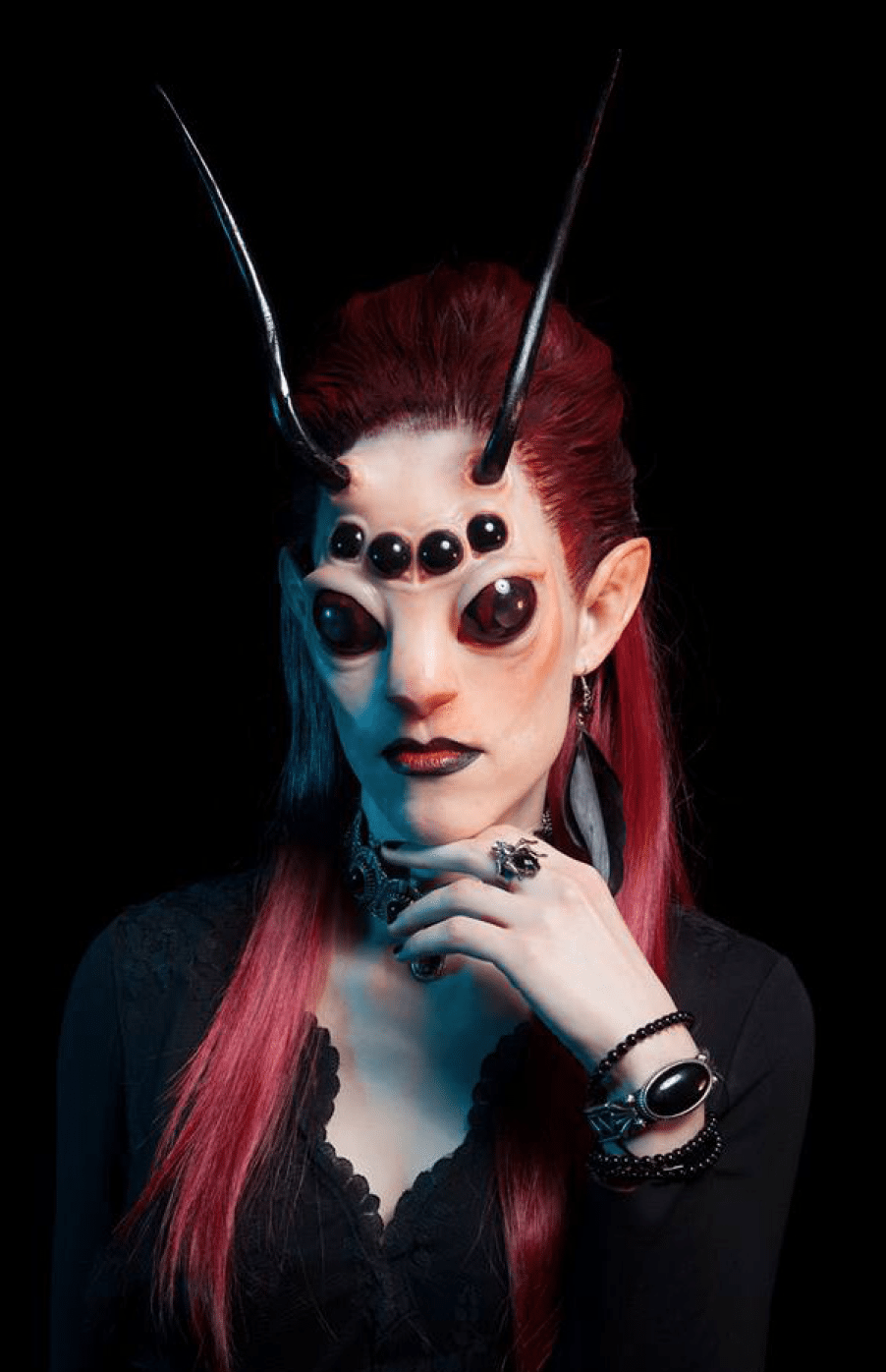Headshot for a model dressed like an alien creature with seven eyes and two antennae.
