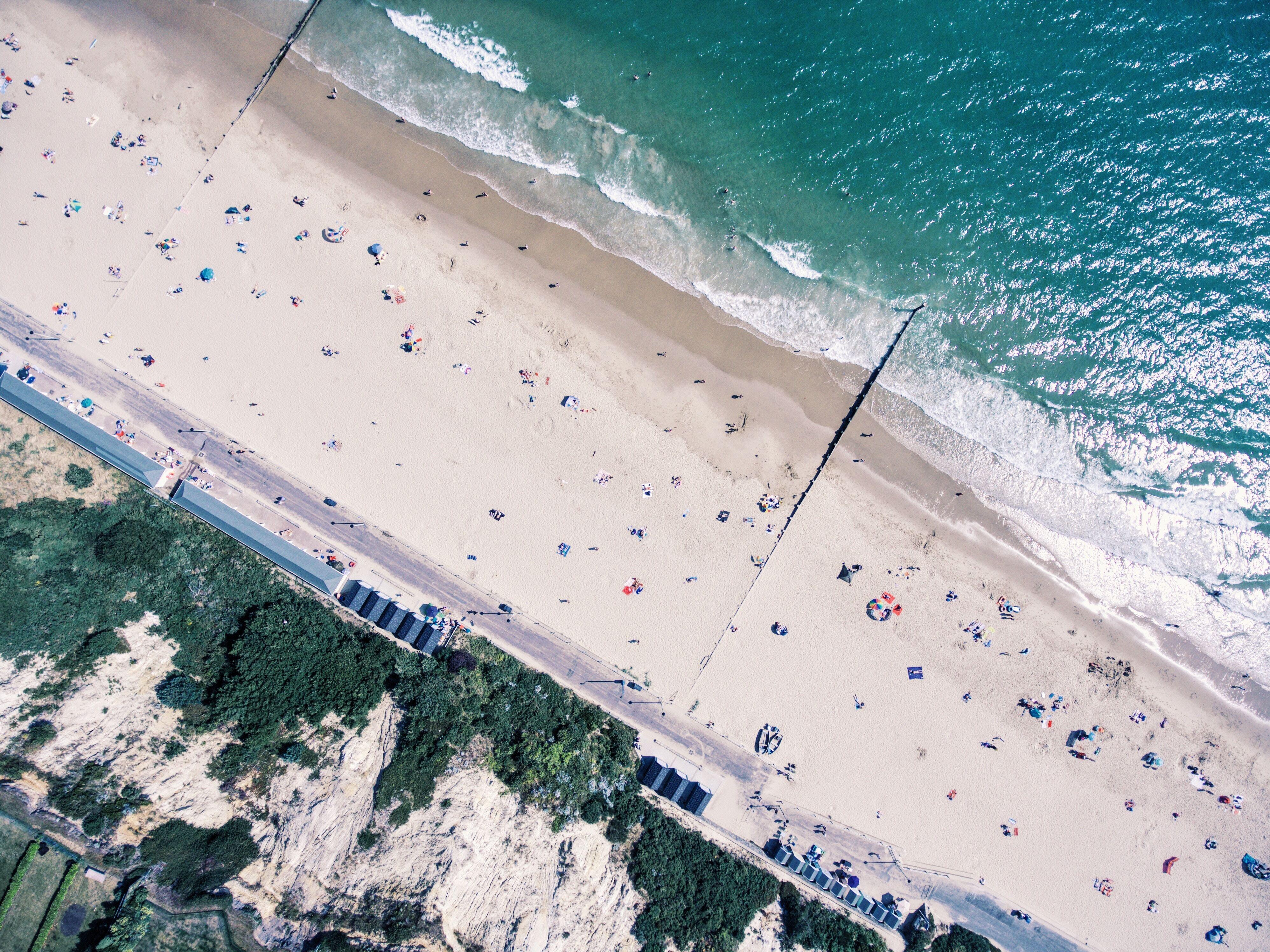 An aerial photograph showing a clifftop, a promenade, a beach and the sea.