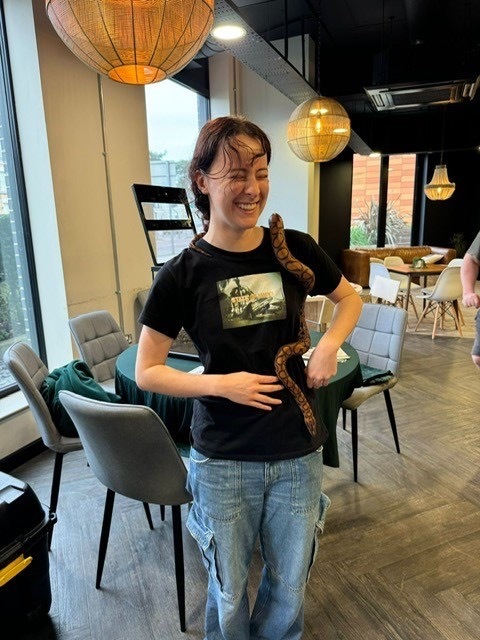 A student holding a snake as part of a ResLife event.
