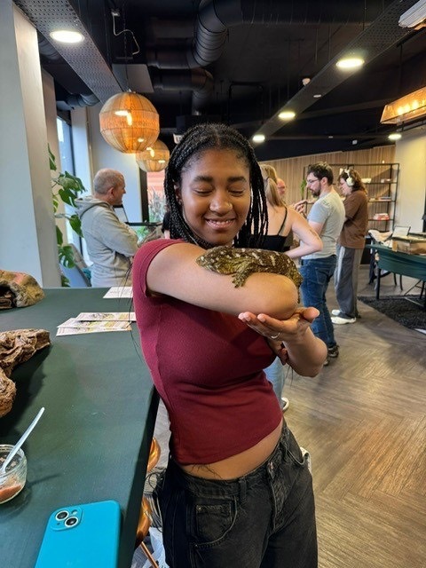 Student holding a lizard as part of a ResLife event.