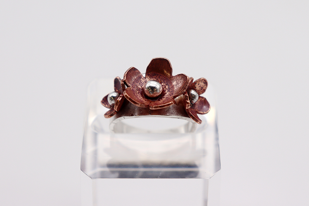A piece of jewellery designed as three flowers.