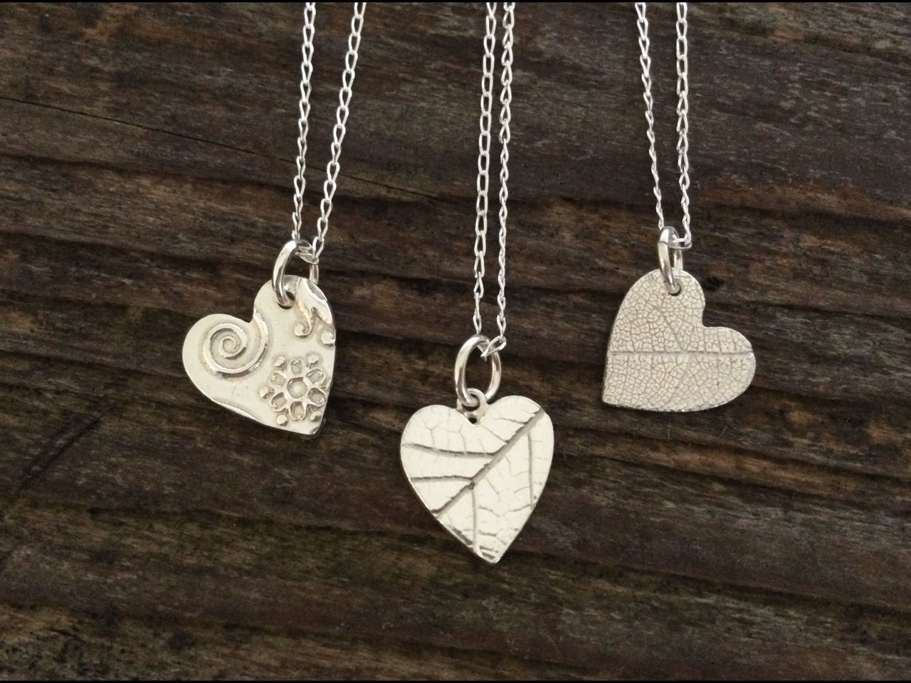 Three heart-shaped necklaces in silver