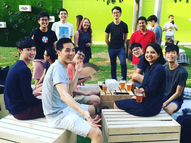 Team of people sitting outside looking at the camera