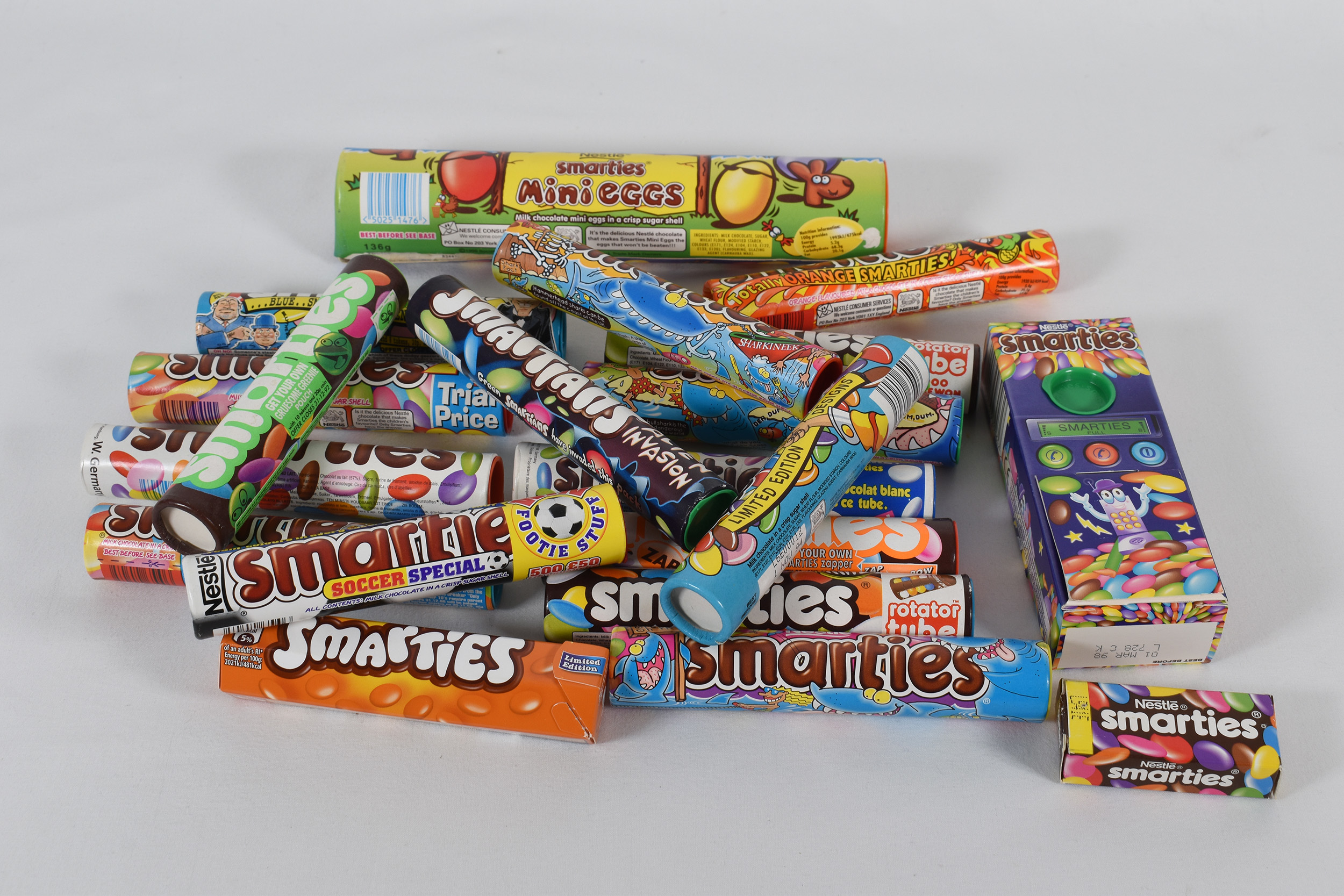 Collection of samples of Smarties chocolate packaging throughout time.