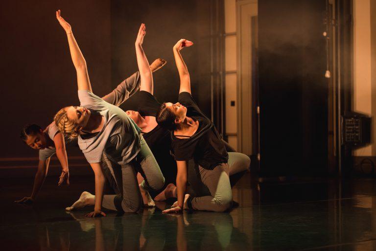 Dance students in the middle of a routine, performing on a stage