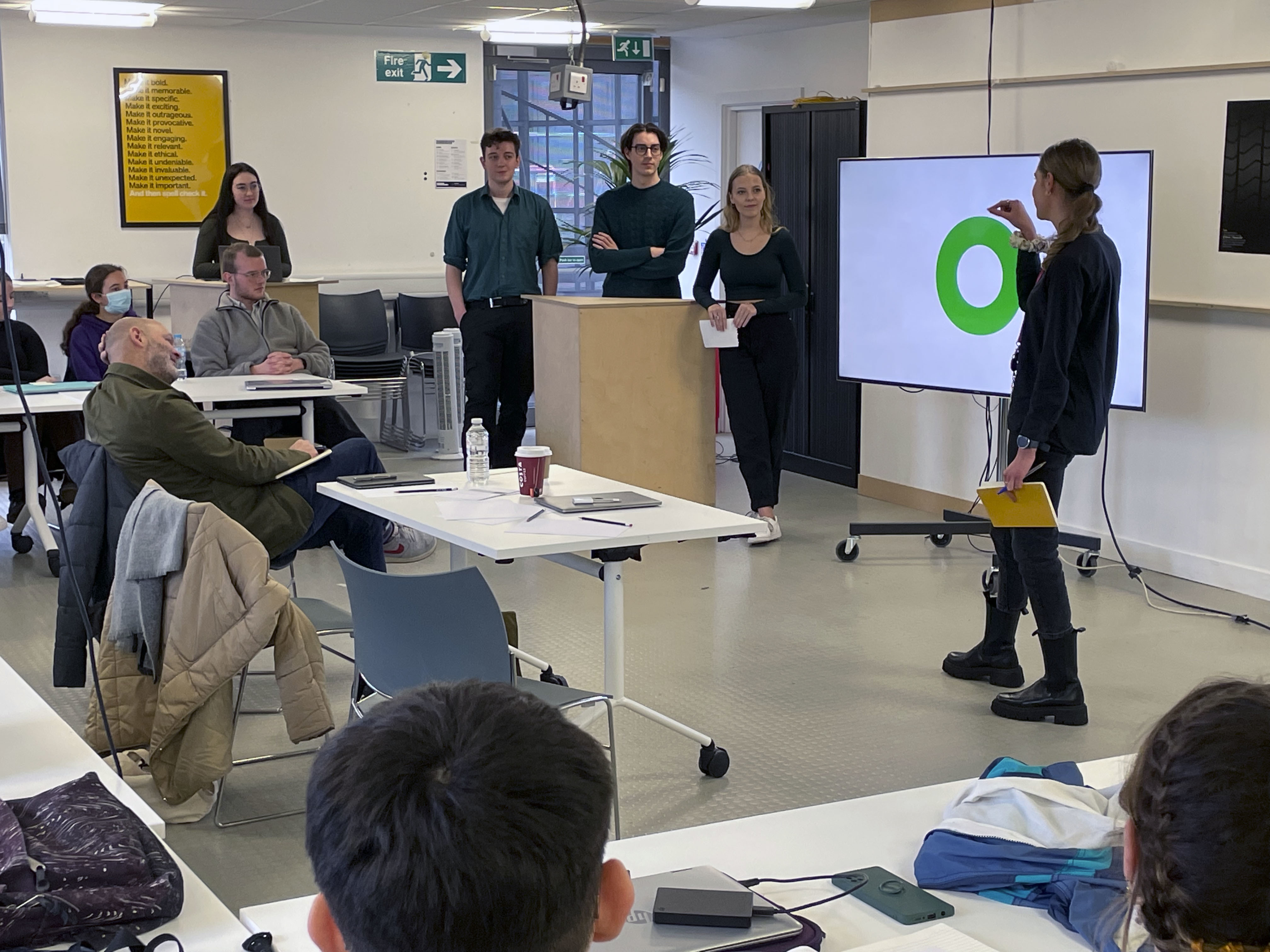 A group of Graphic Design students give a presentation in front of a classroom audience