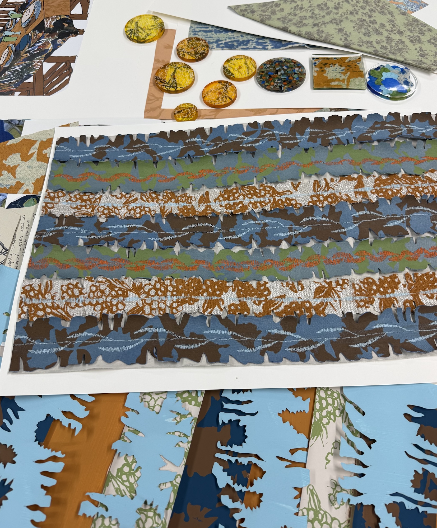 Close-ups of abstract, colourful textiles designs on a white tabletop.