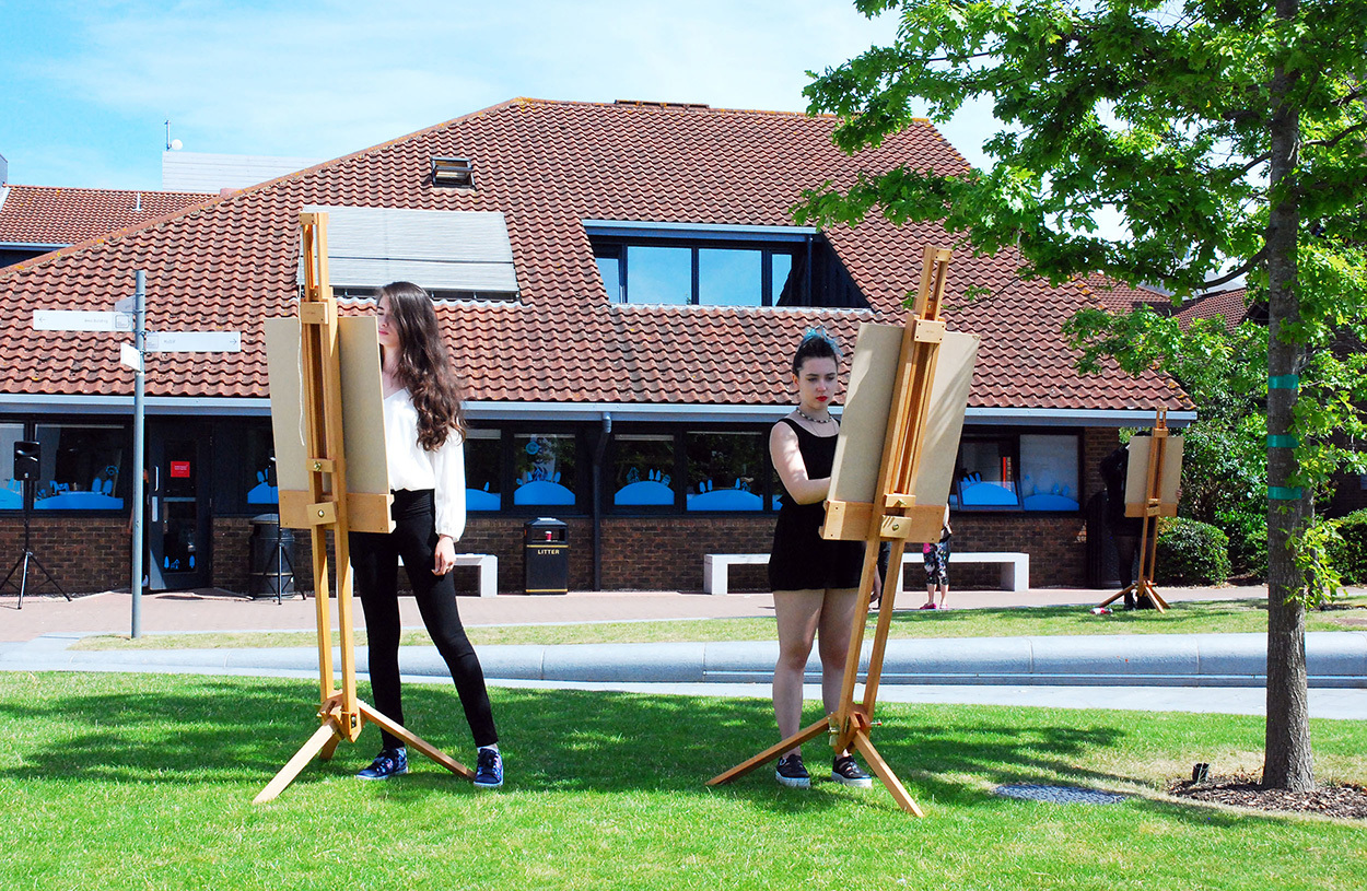 Students outside drawing on easels
