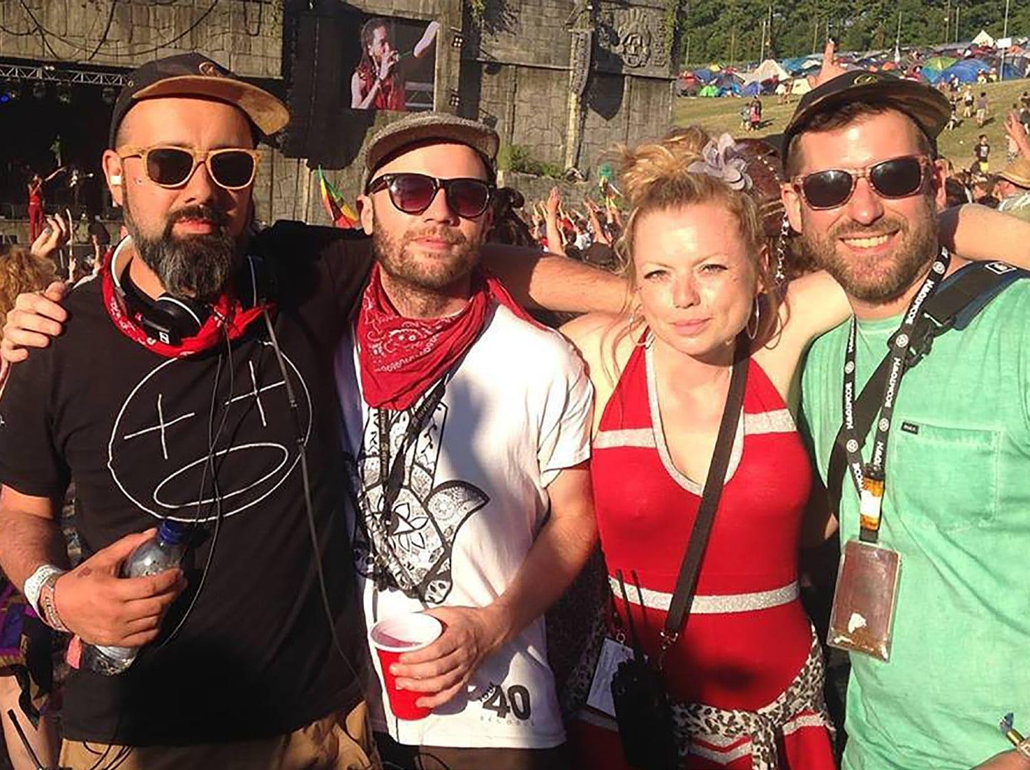 Four people pose for a photo at a festival