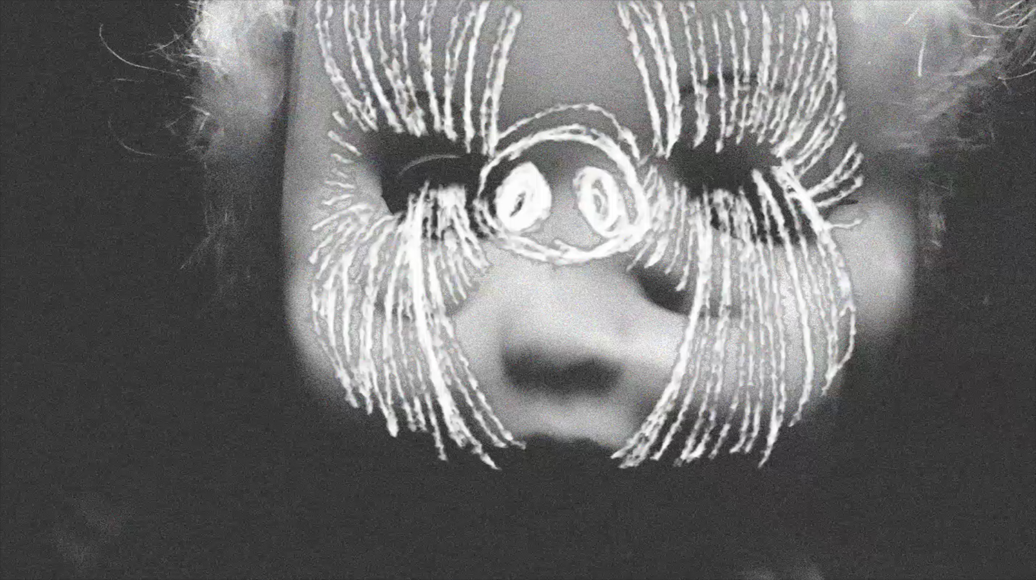 A black and white photo of a doll's face with lines scratched into it