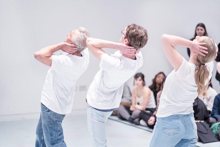 Three people leaning backwards with their hands behind their heads.
