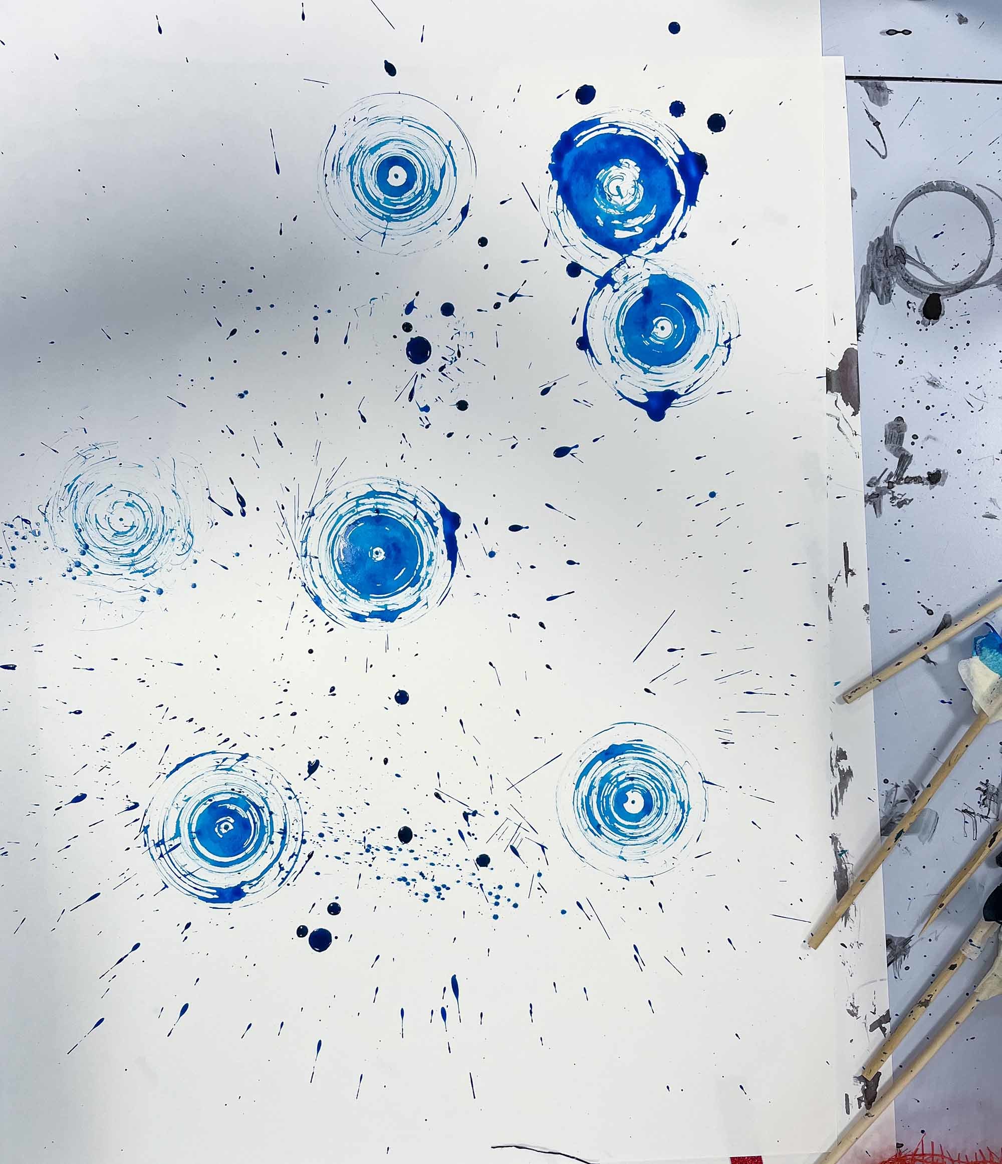 A series of blue painted circles on a canvas
