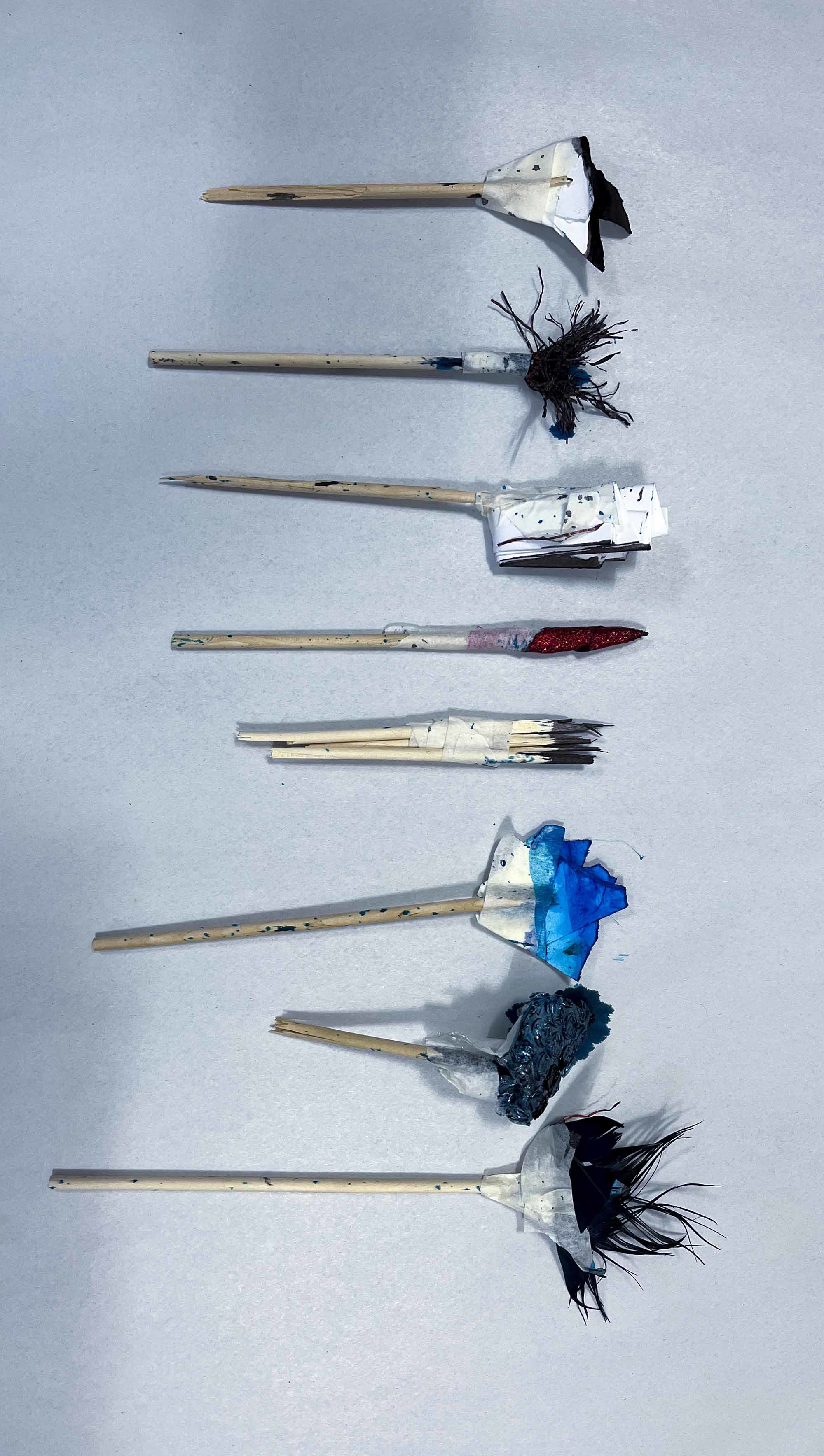 Different artistic paint brushes laid out on a plain surface