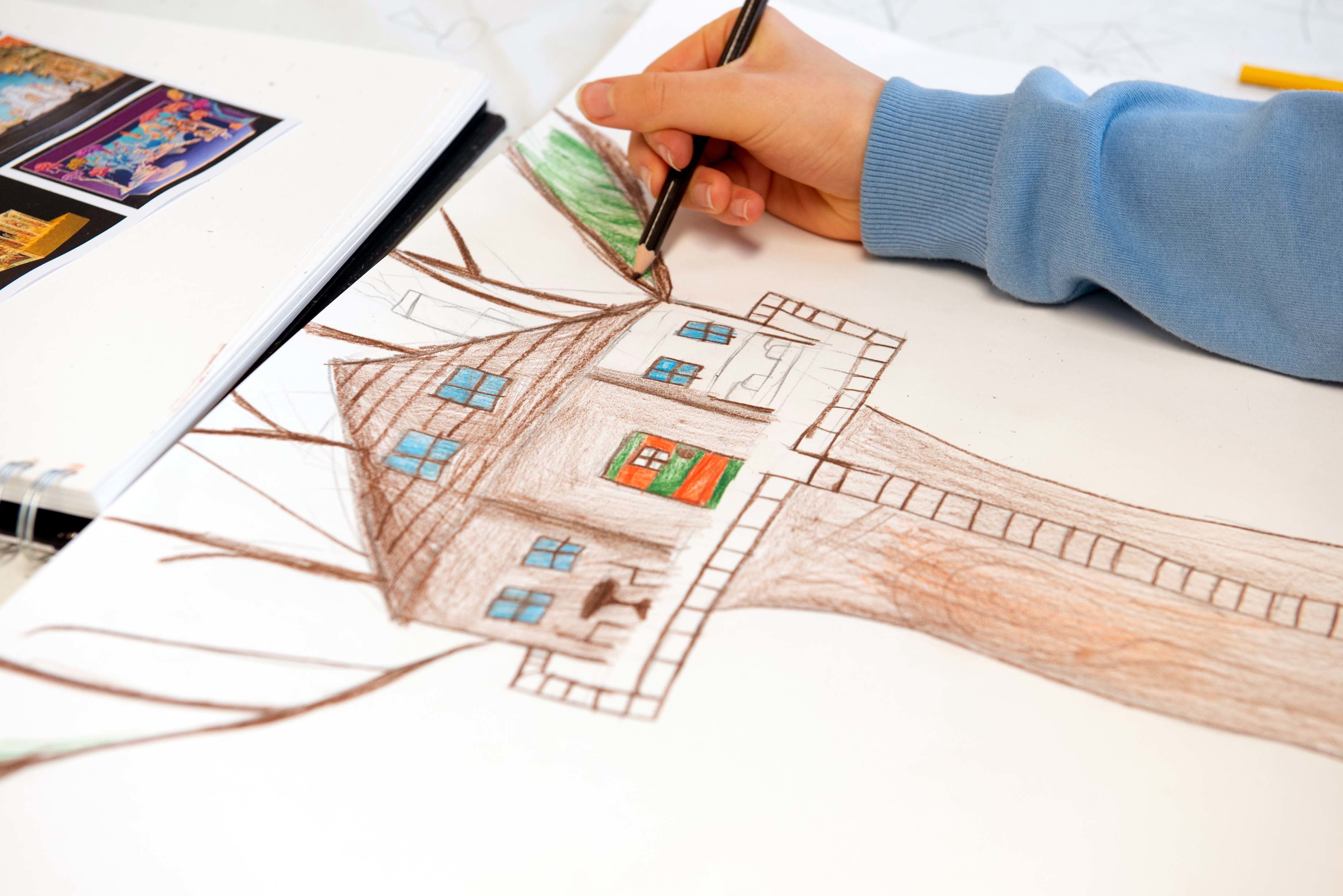 Someone draws a tree house in coloured pencils on a piece of paper.
