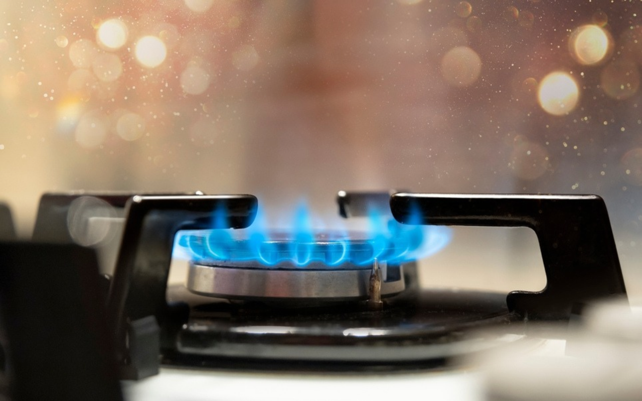 Close up of a gas stove releasing fossil gas as a health hazard into the home