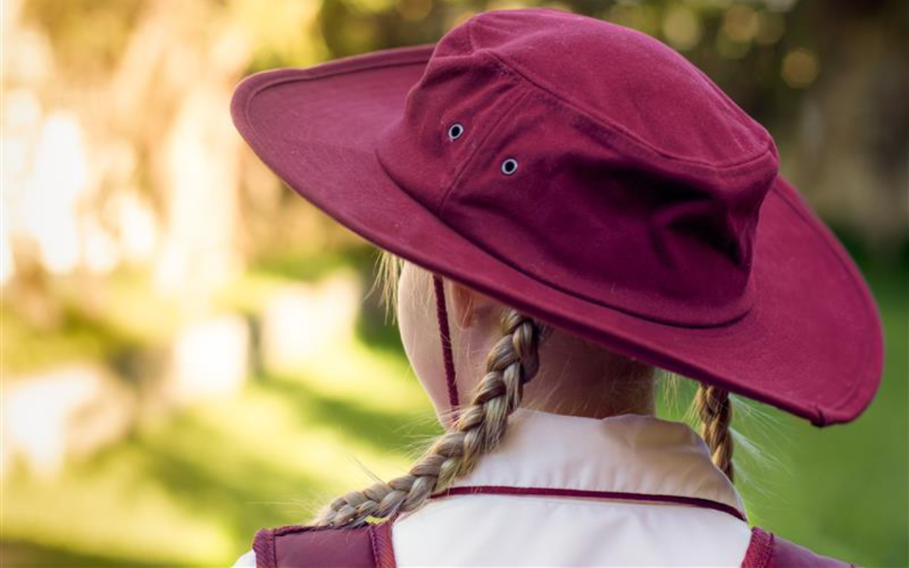 A young schoolgirl in her maroon school hat
