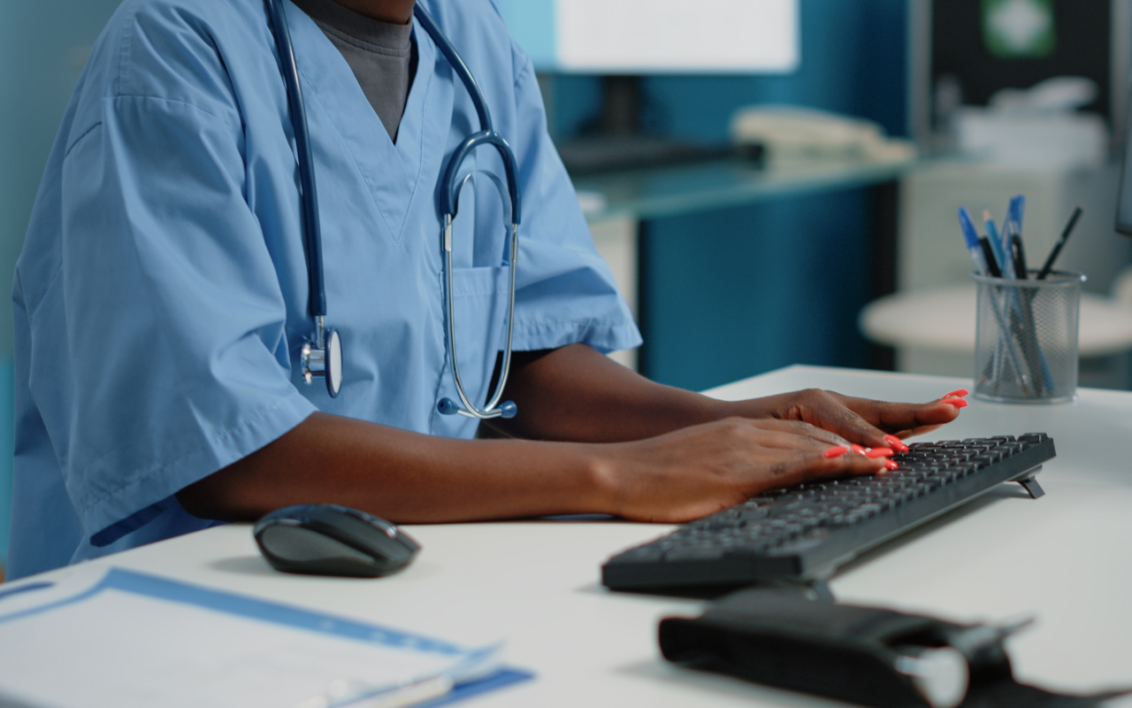 a doctor sits at computer typing, running a medical practice