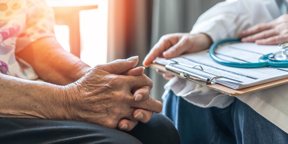 close-up of hands of doctor and patient discussing palliative care and serious illness conversations