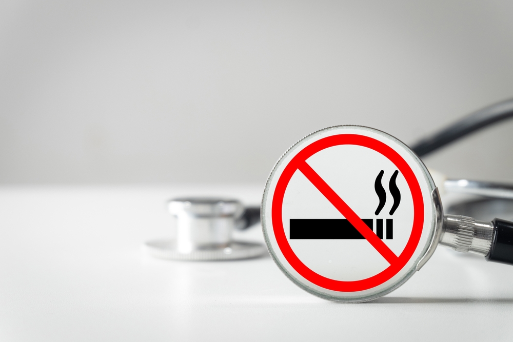 A no smoking sign in front of a stethoscope