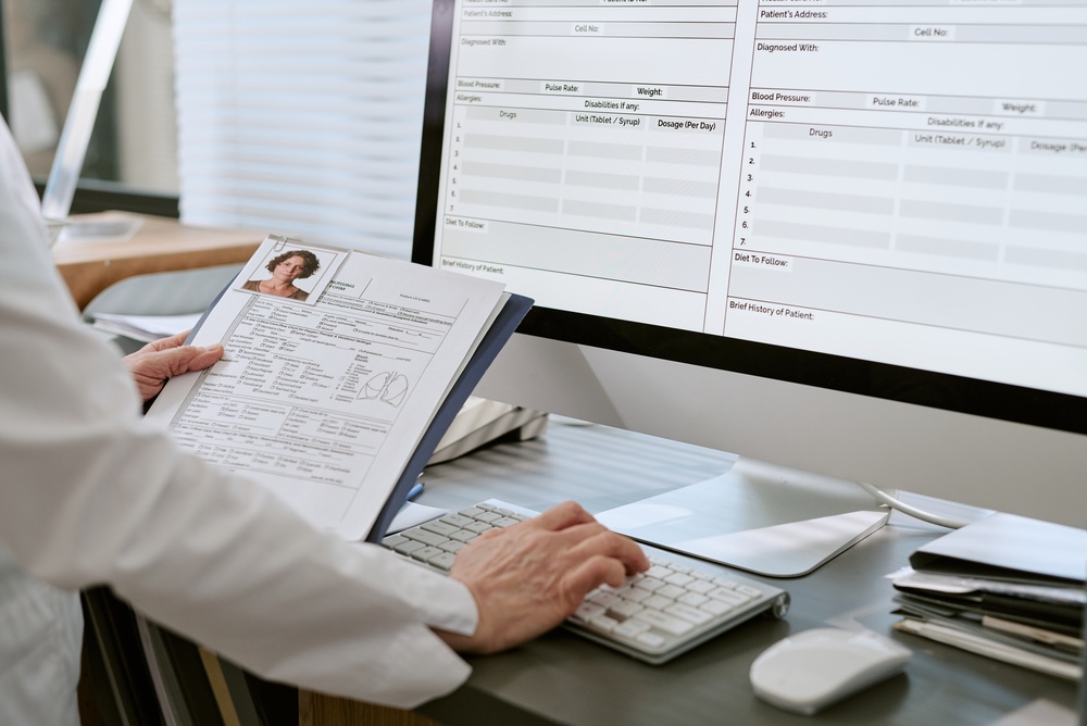 Doctor inputting patient data on computer using AI