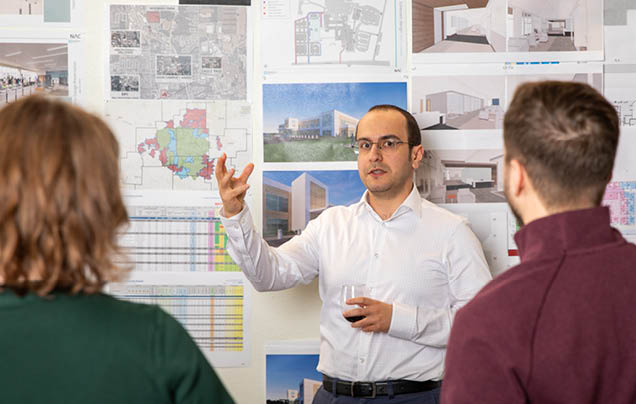 A man pointing at a drawing on a wall. Description generated by AI