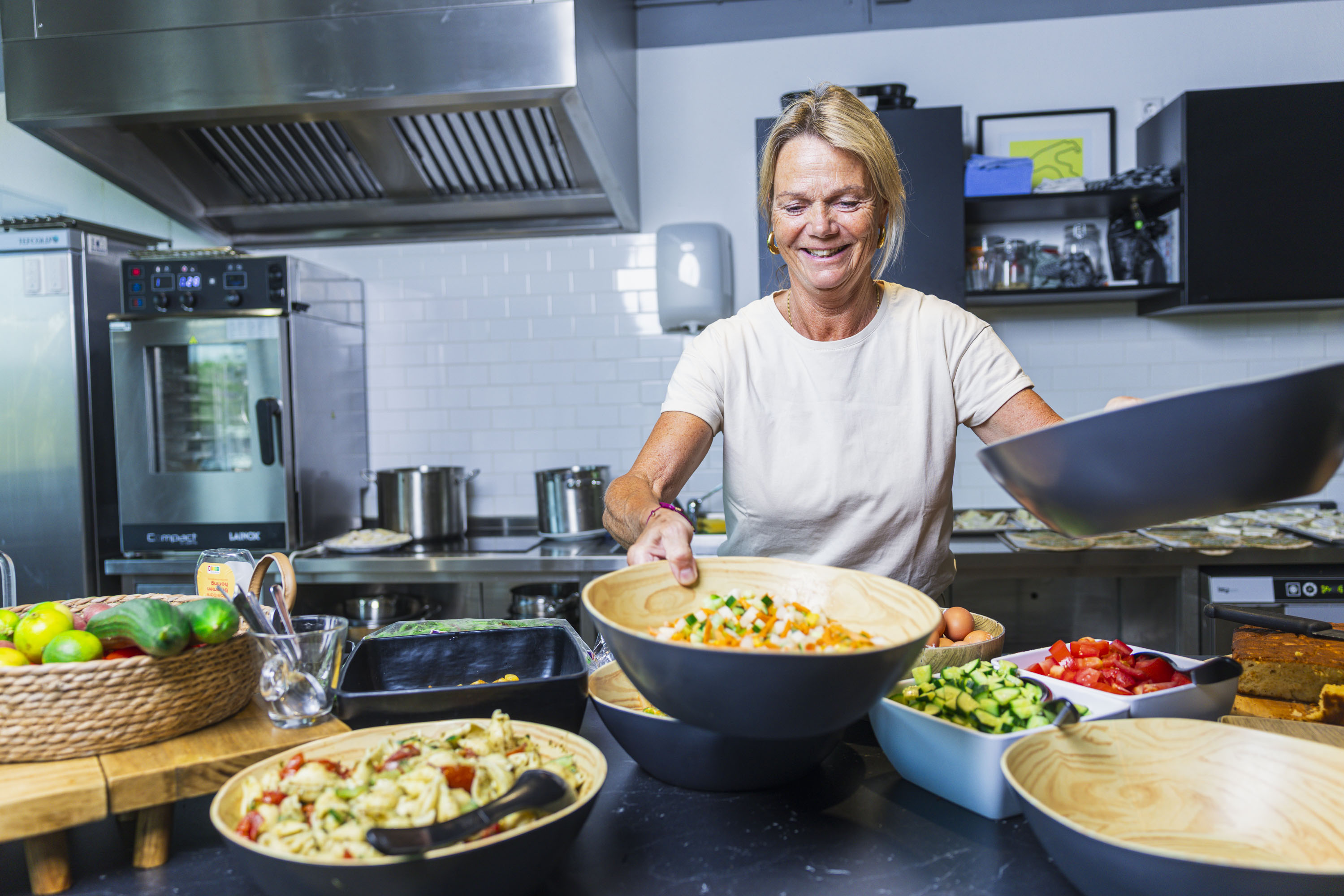 Colleague serving salad in the office kitchen