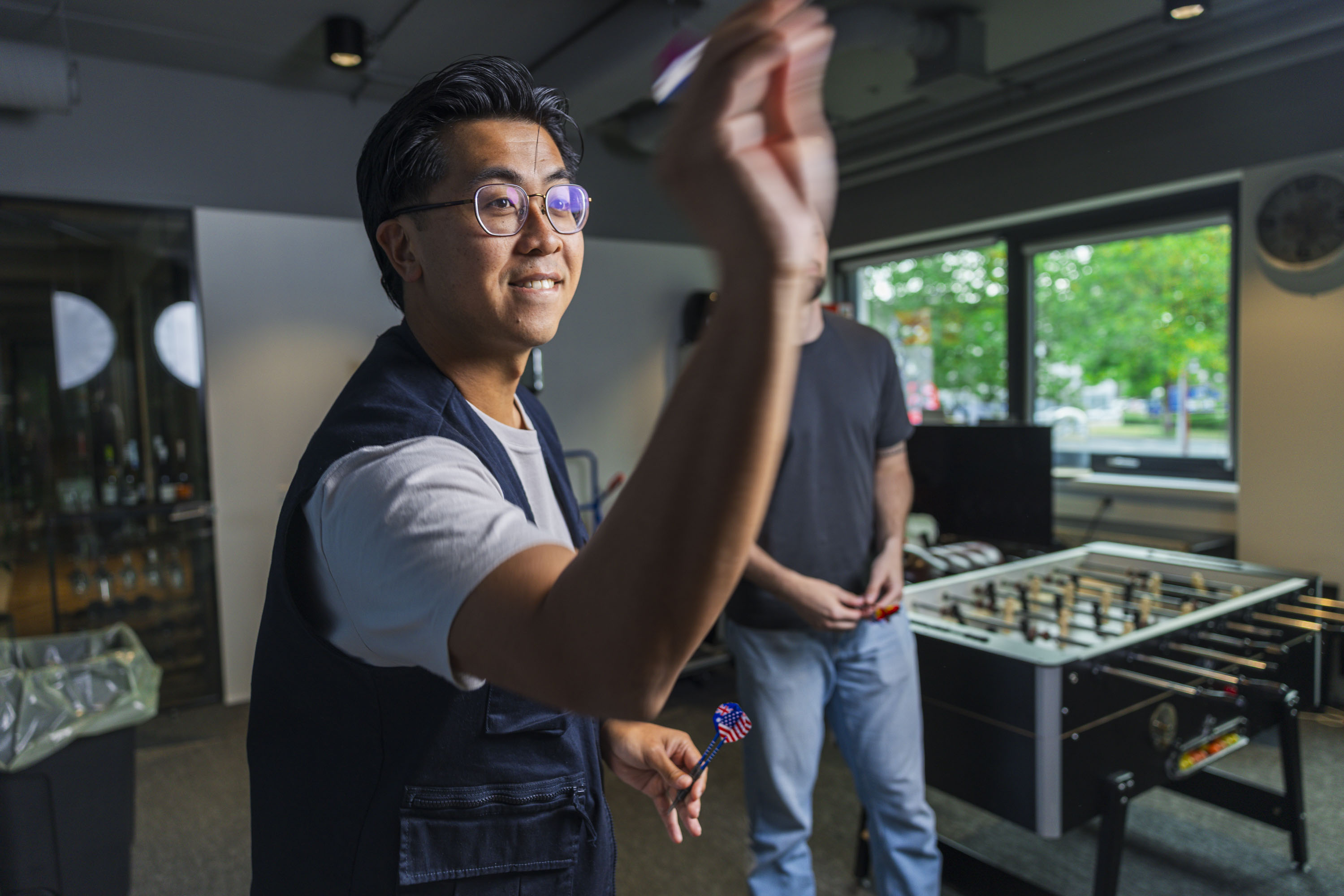 Colleague throwing a dart in the office games area