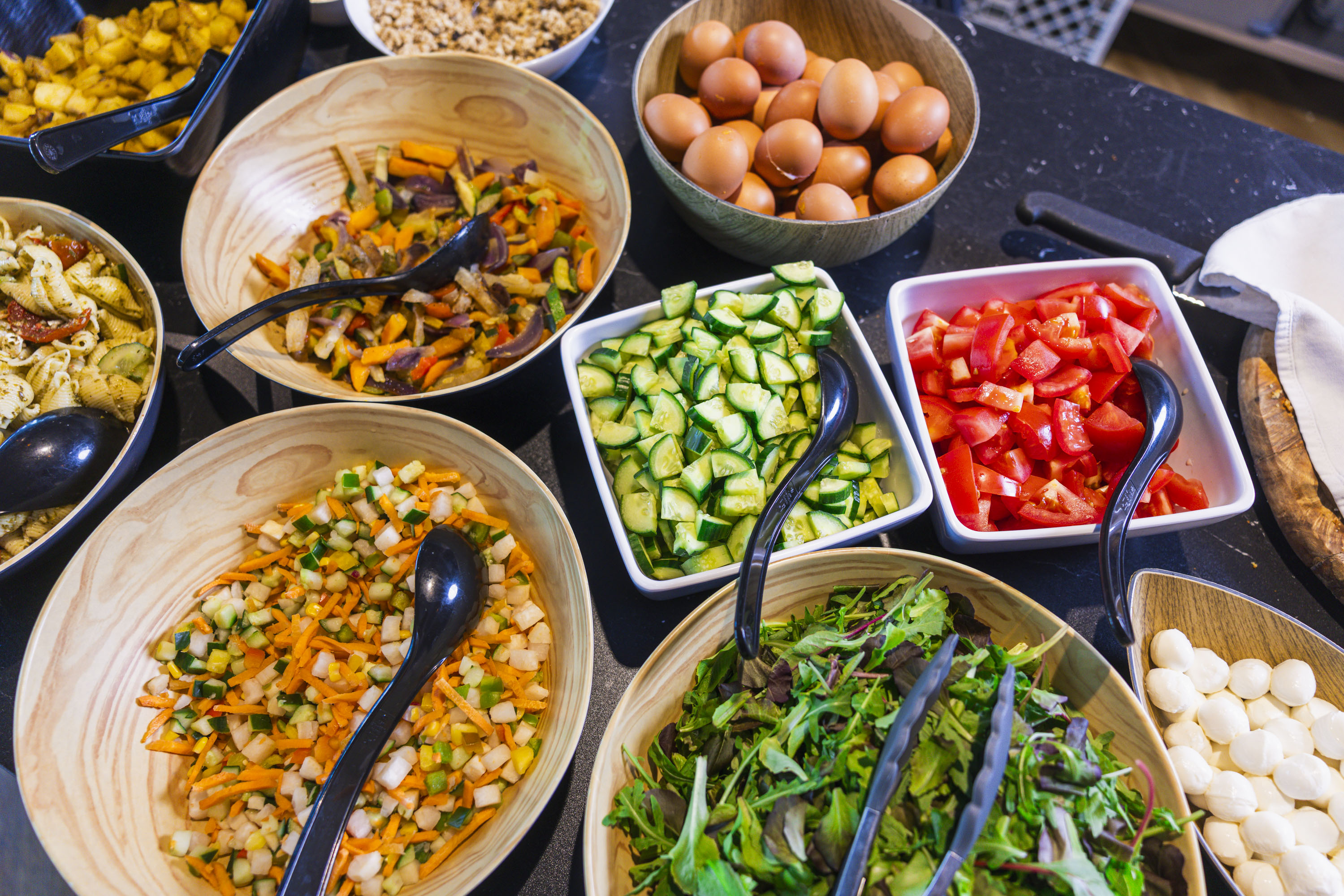 Buffet table with bowls of salads and vegetables
