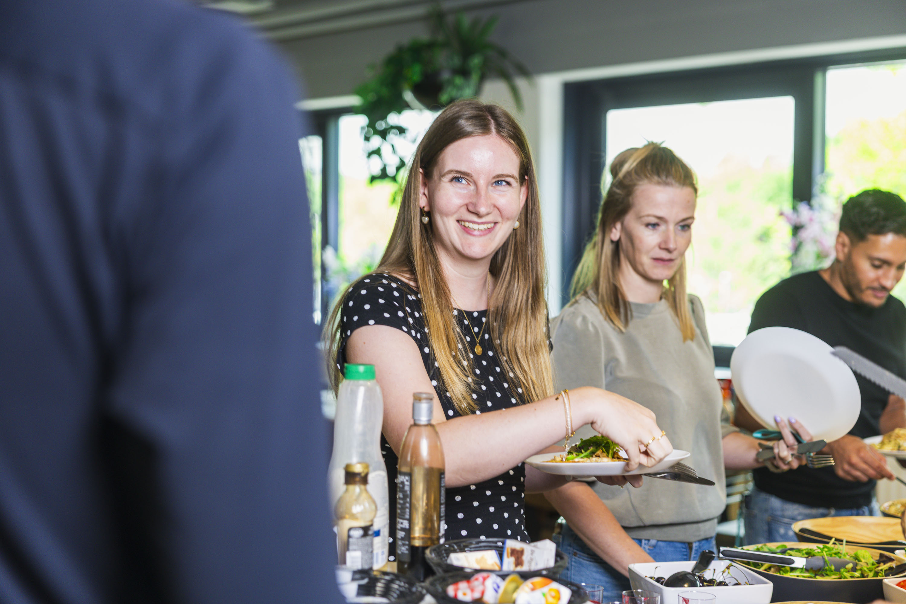 Two colleagues filling their plates at a lunch buffet