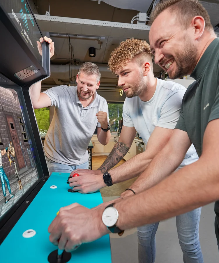 Colleagues playing an arcade game together
