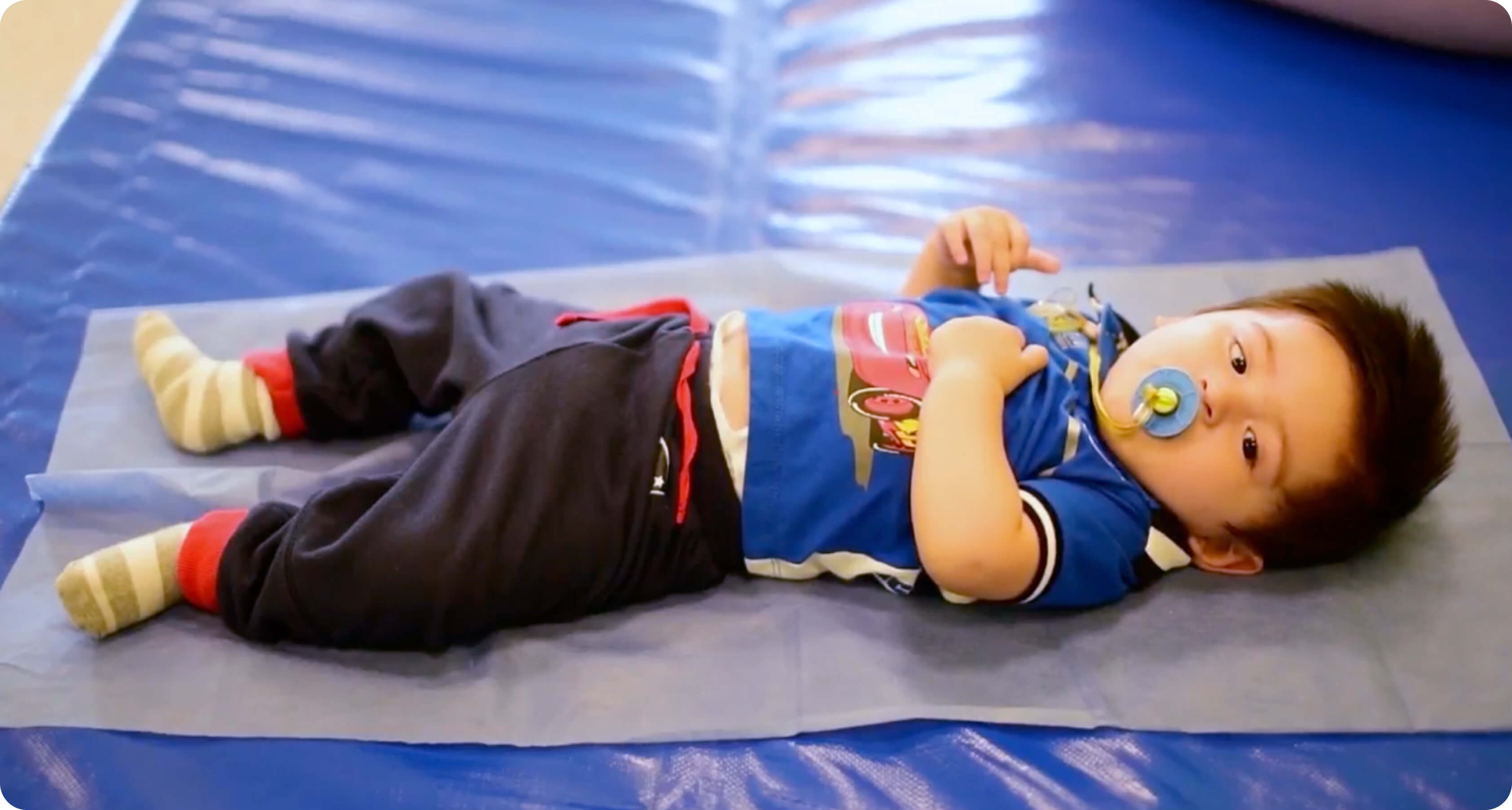 Toddler laying down on a floor mat