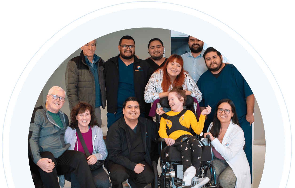 Team at NeuroCytonix standing with girl in a wheelchair