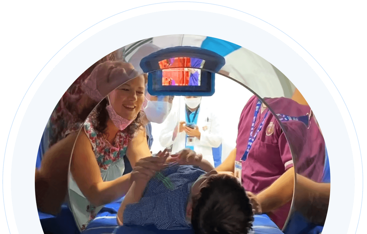 Boy laying in NeuroCytonix device and healthcare providers standing next to him