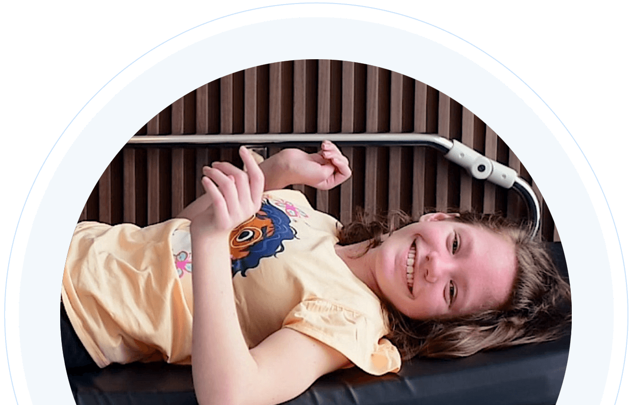 Young girl smiling and laying down at the clinic