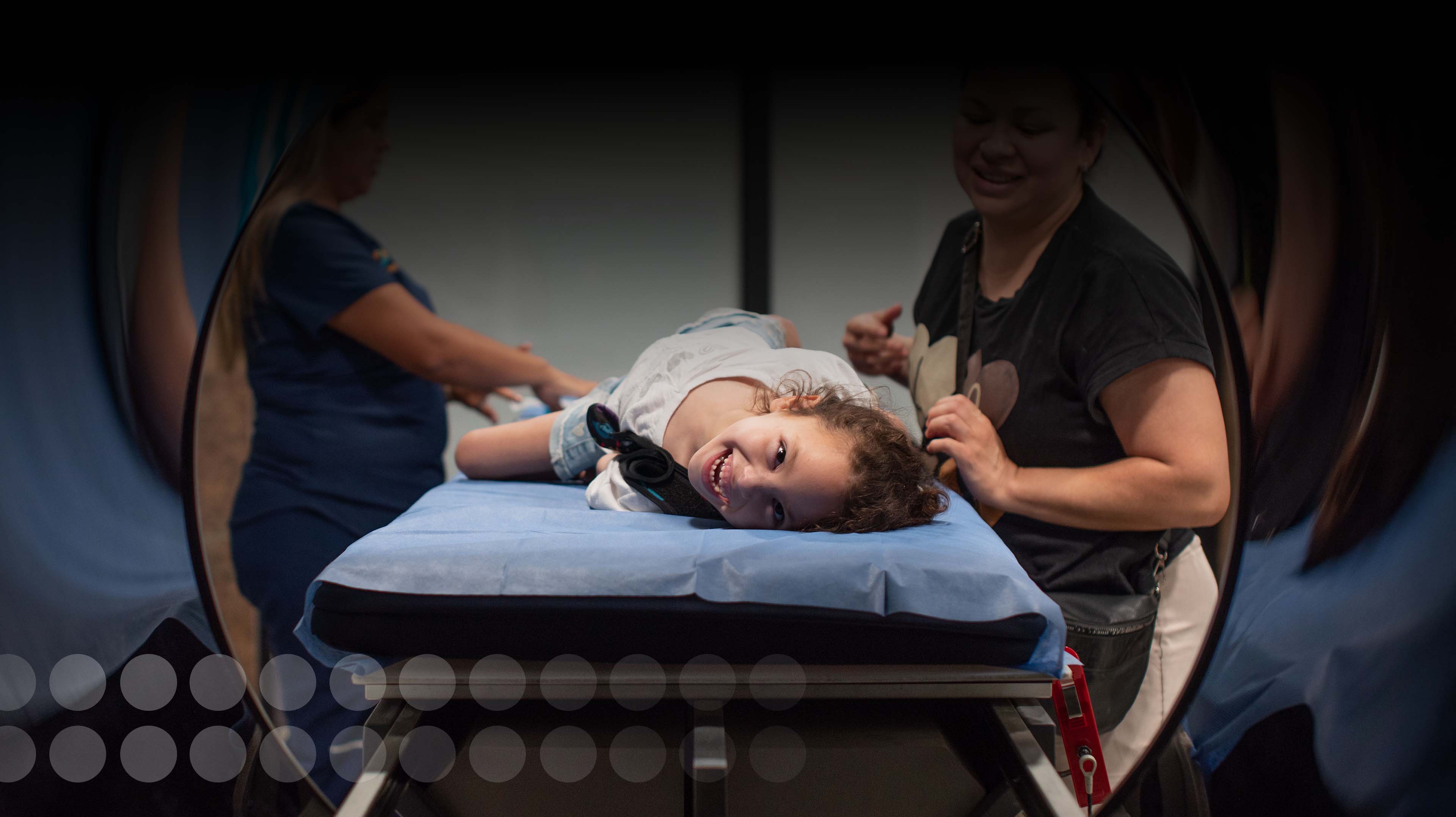 Boy with head in his hands smiling and laying down in neurocytotron device