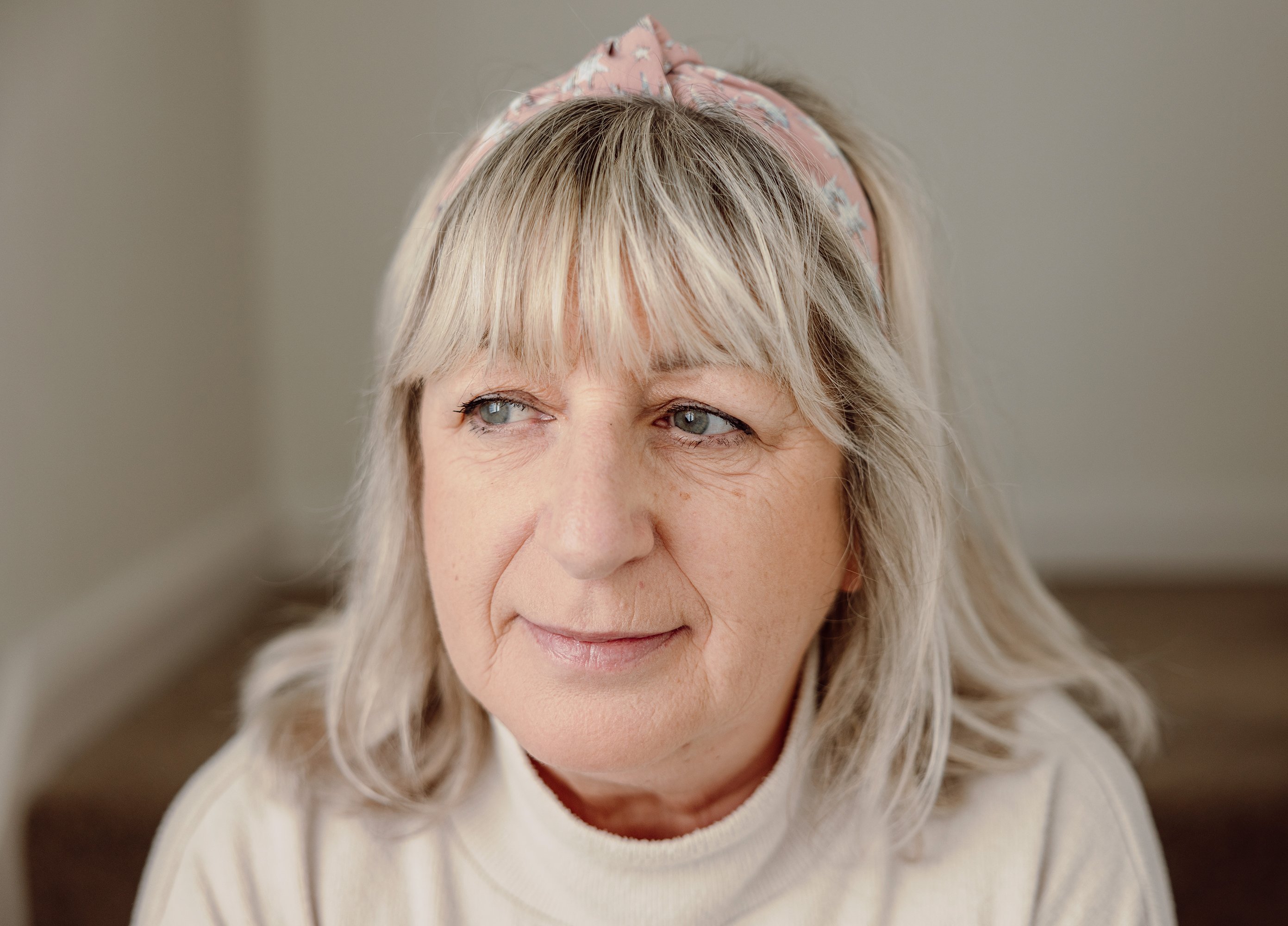 A close-up portrait of a woman with shoulder-length hair and a patterned headband looking to one side, representing an anonymous WiSE attendee.
