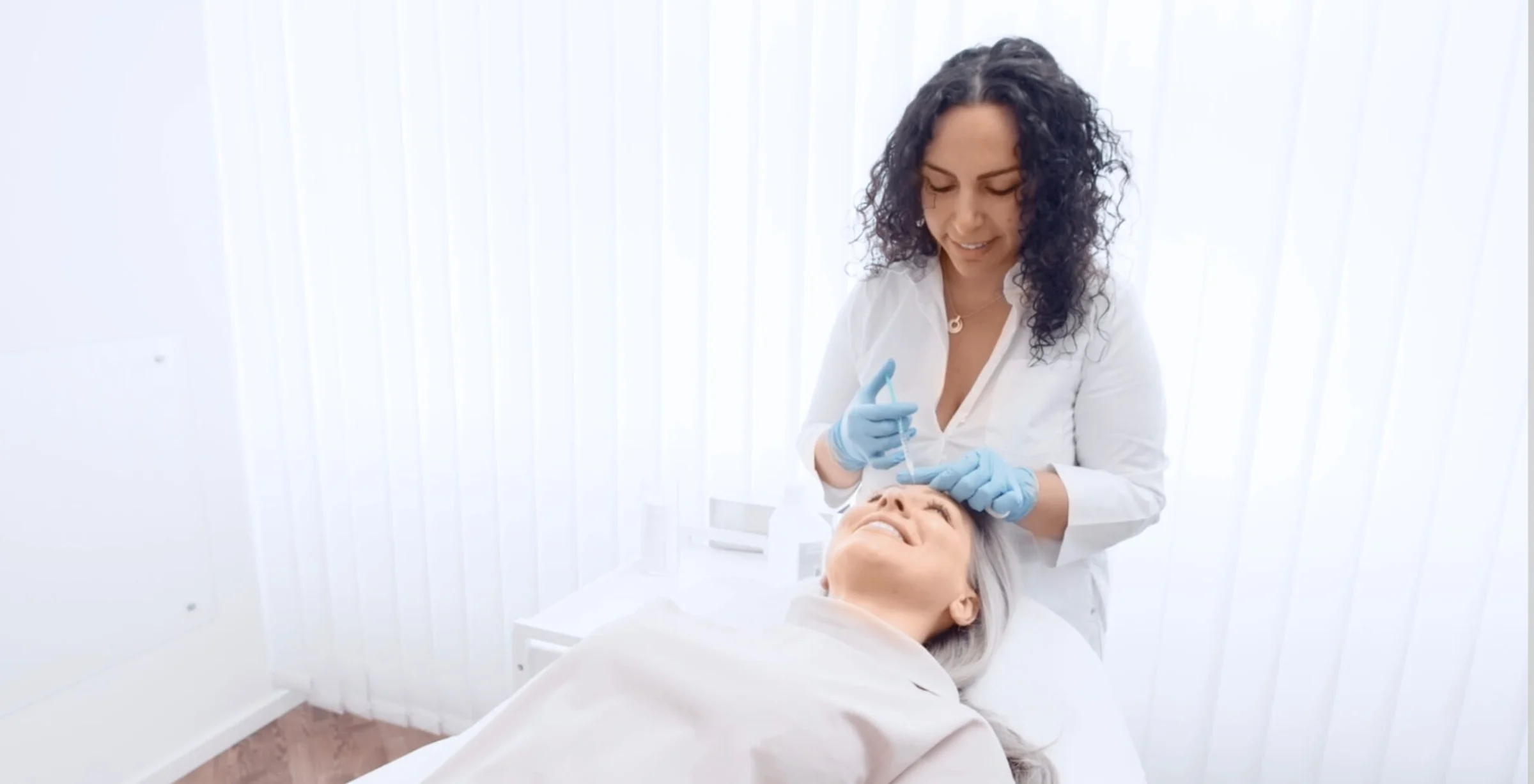 Auf dem Bild erkennt man eine Patientin die auf einer Liege liegt und gerade eine Botox Behandlung von Dermacares Ärzten erhaltet.