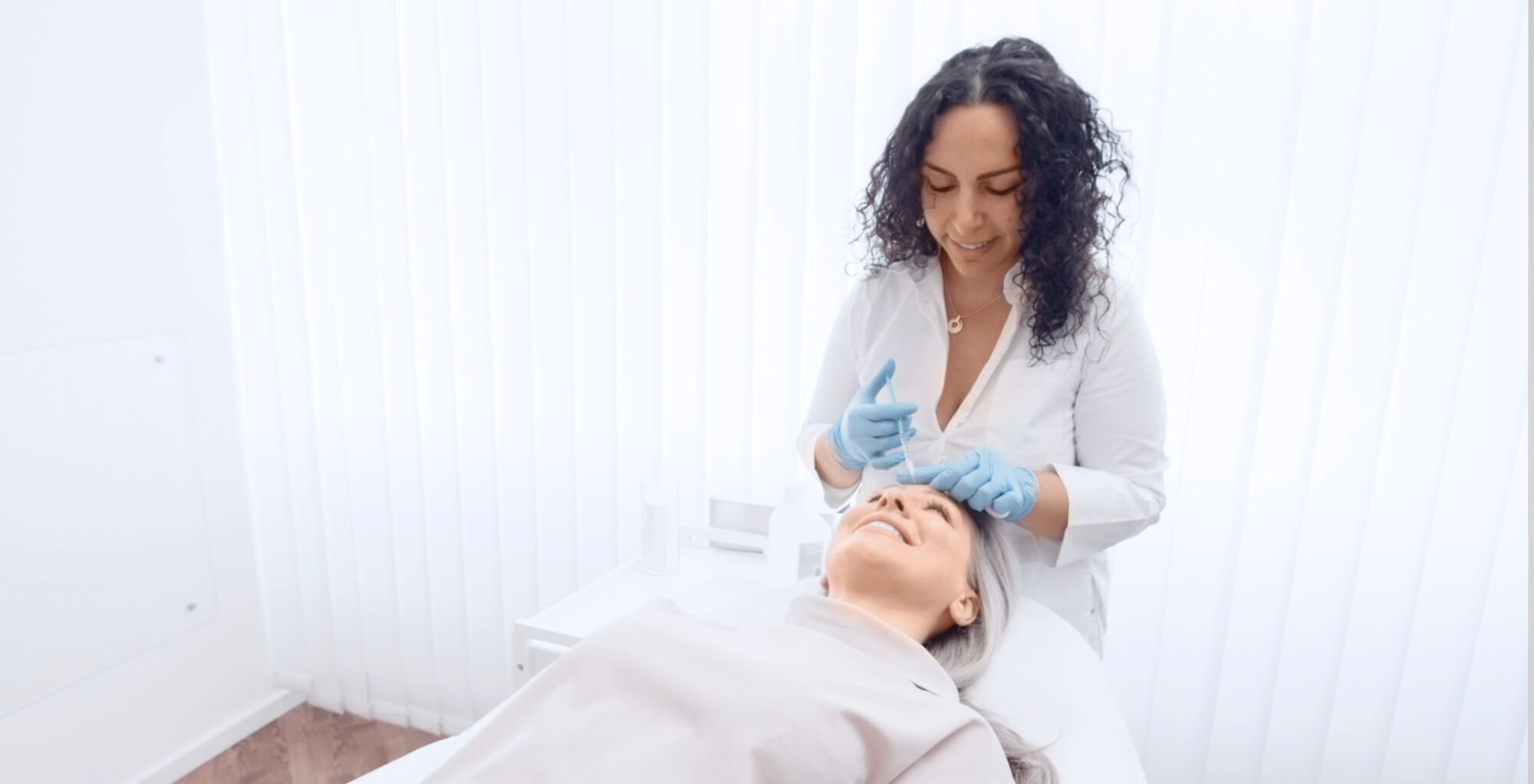 Auf dem Bild erkennt man eine Patientin die auf einer Liege liegt und gerade eine Botox Behandlung von Dermacares Ärzten erhaltet.