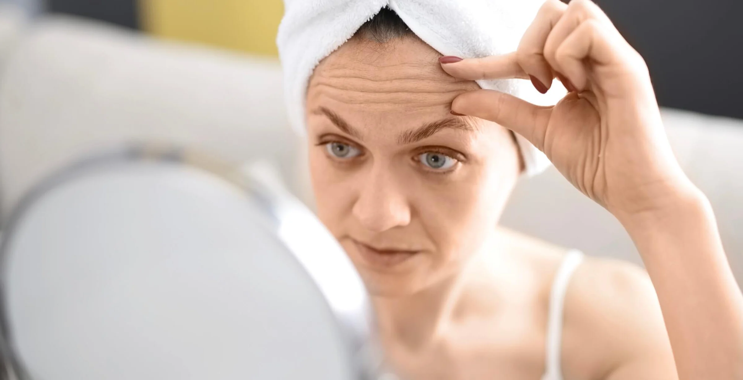 Die Frau auf dem Bild wundert sich gerade ob eine Faltenunterspritzung mit Botox ihre Stirnfalten glätten kann.