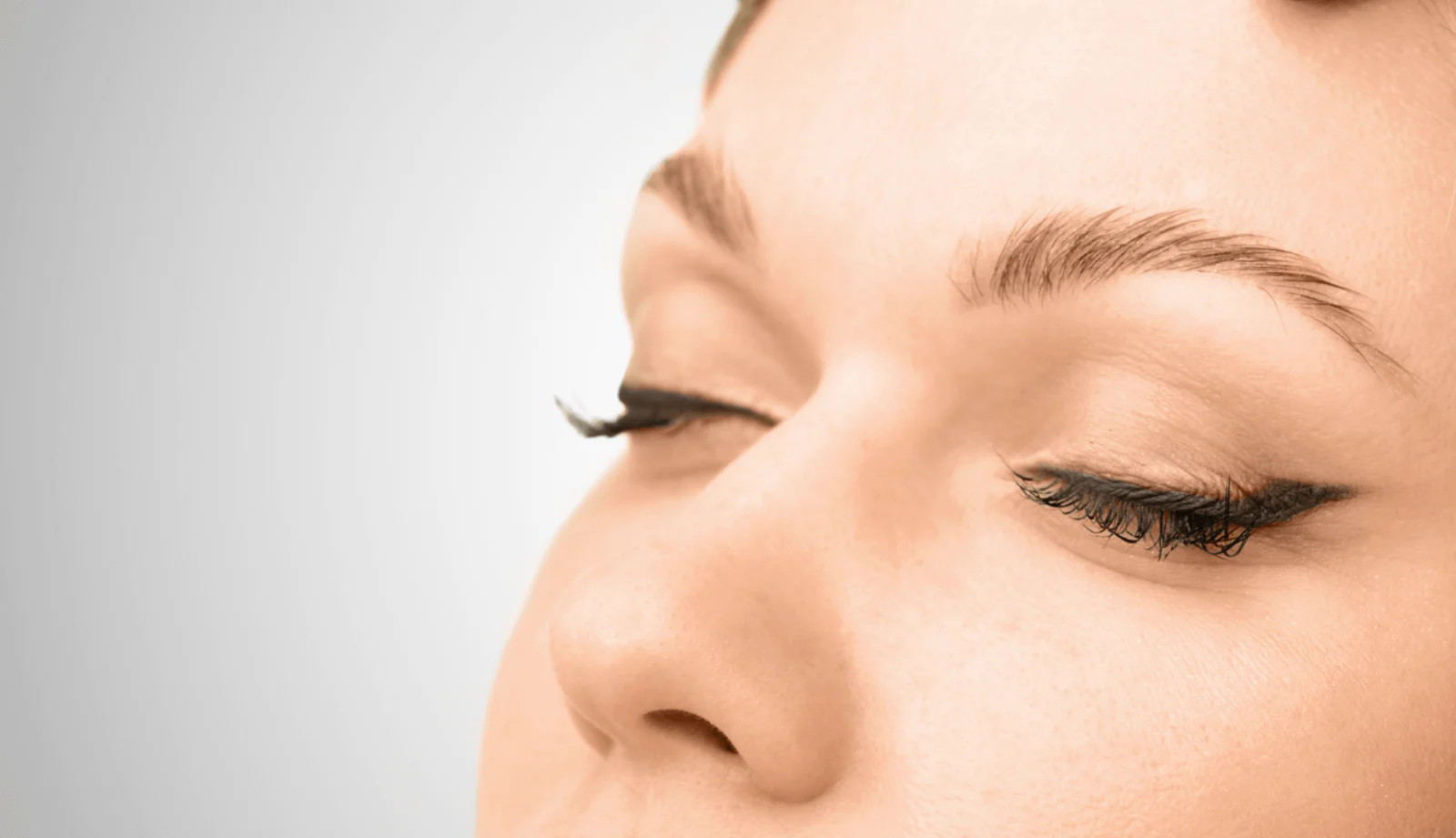 Das Bild zeigt die geschlossenen Augen einer Frau, die Ruhe und Zufriedenheit ausstrahlt. Sie hat einen zuvor schlecht gestochenen Permanent-Make-up-Lidstrich entfernen lassen und ist nun mit dem verbesserten Ergebnis zufrieden. Die Haut wirkt gepflegt, und der Bereich um die Augen zeigt keine sichtbaren Spuren des früheren Lidstrichs. Dermacare Wien bietet das professionelle Permanent Lidstrich Entfernen mit modernster Lasertechnologie an, um unerwünschtes Permanent Make-up sicher und effektiv zu korrigieren.